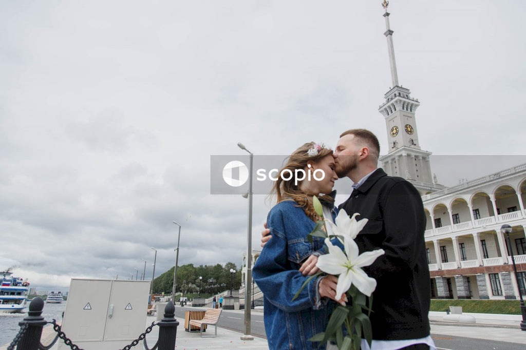Man in black suit jacket holding woman in blue denim jacket