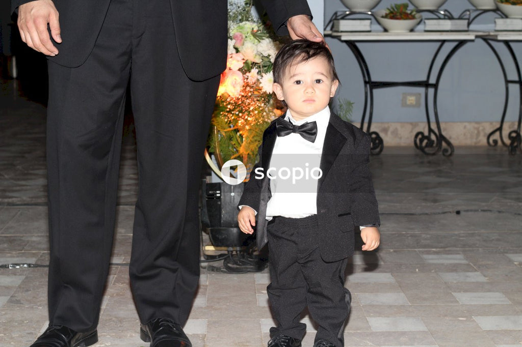 Man in black suit jacket hugging girl in black and white dress