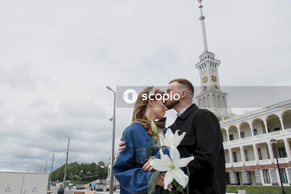 Man in black suit jacket hugging woman in blue dress