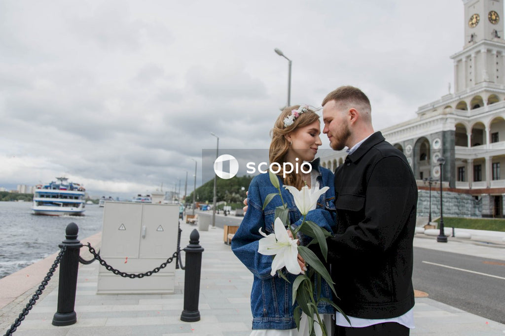 Man in black suit jacket hugging woman in blue dress
