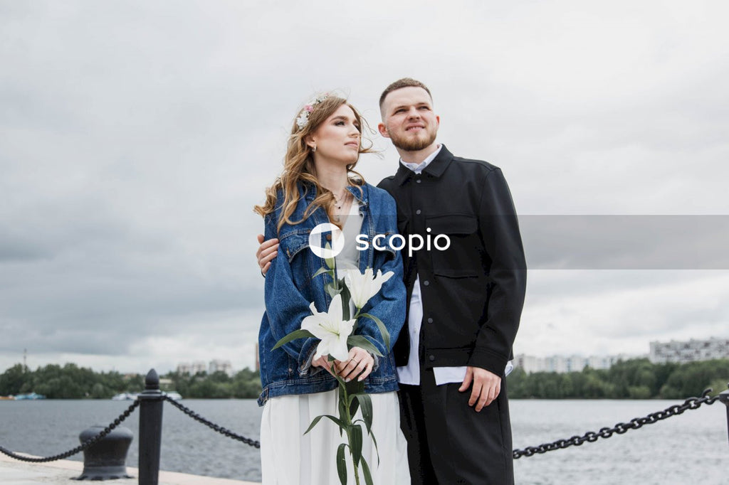 Man in black suit jacket hugging woman in green dress
