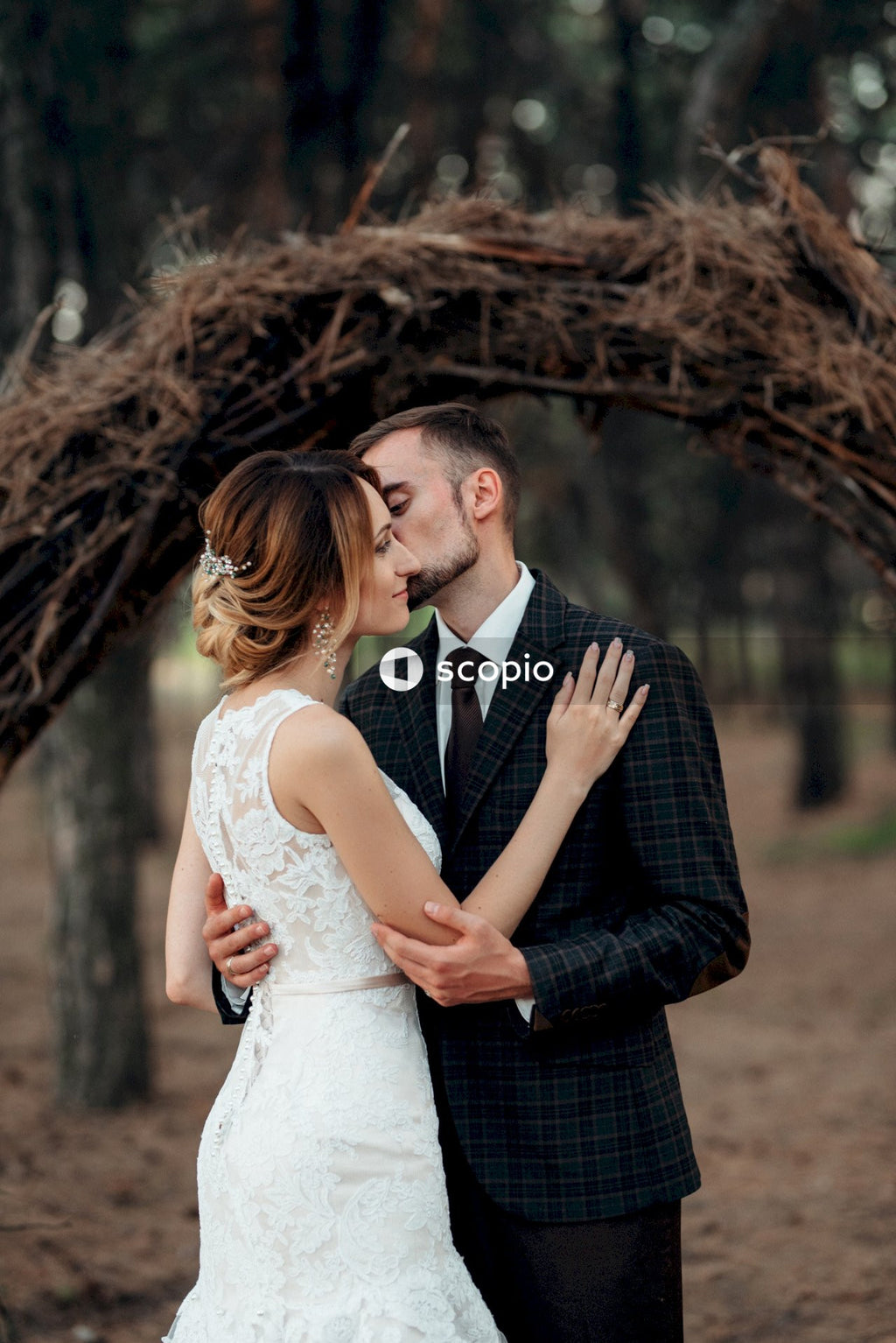 Man in black suit jacket hugging woman in white dress