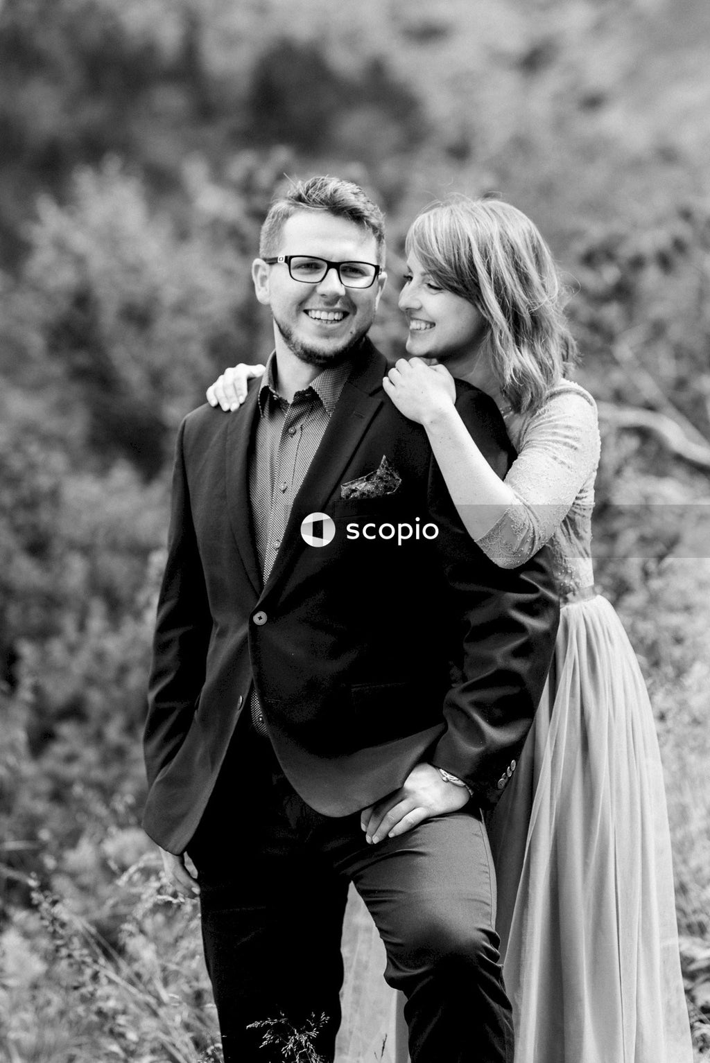 Man in black suit jacket kissing woman in white dress