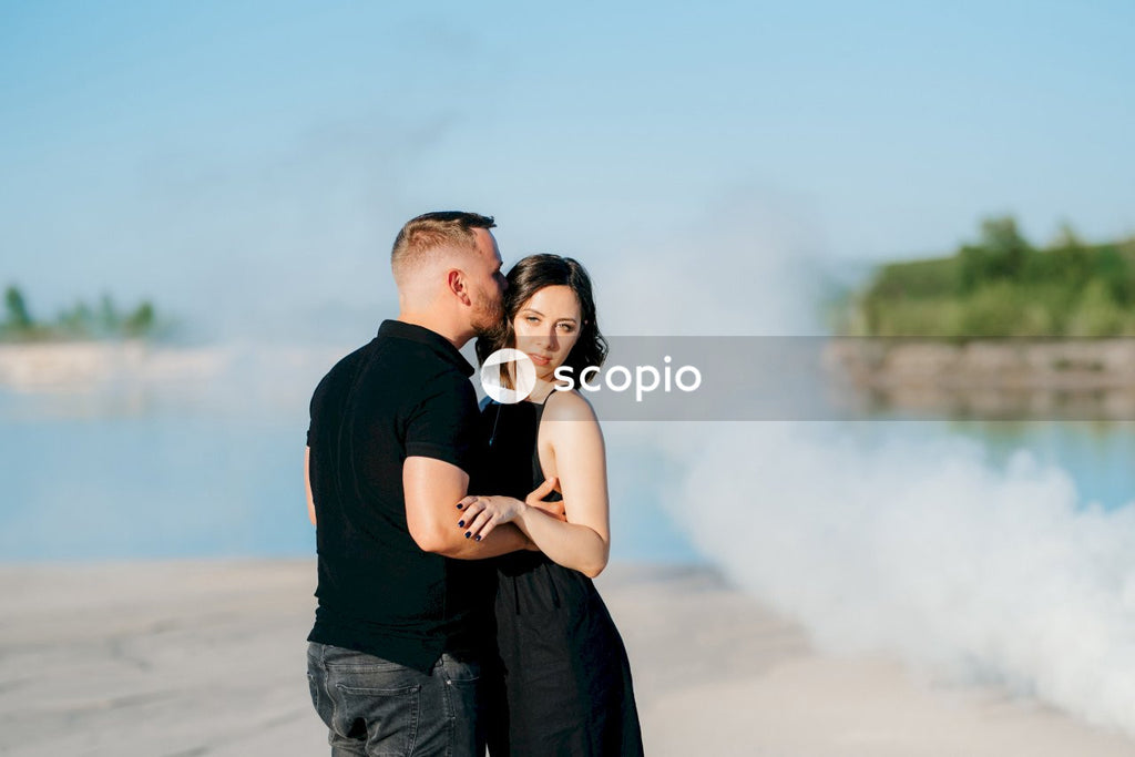Man in black t-shirt hugging woman in black sleeveless dress