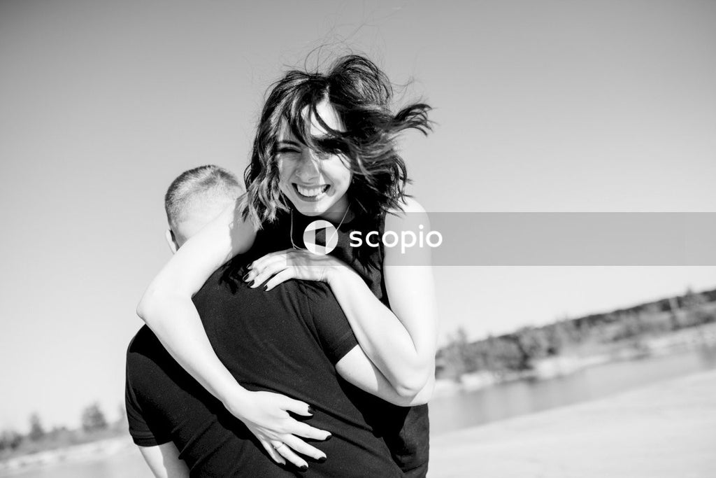 Man in black tank top hugging woman in black tank top