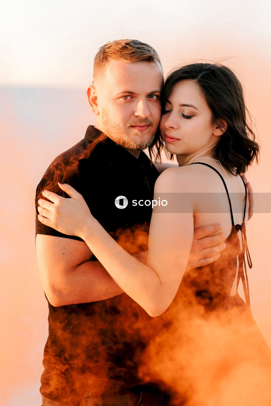 Man in black tank top hugging woman in black tank top