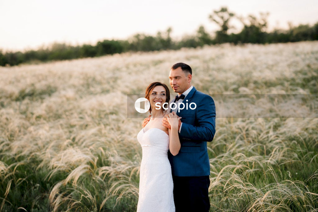 Man in blue blazer hugging woman in white dress