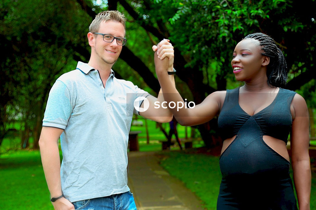 Man in blue polo shirt standing beside woman in black tank top
