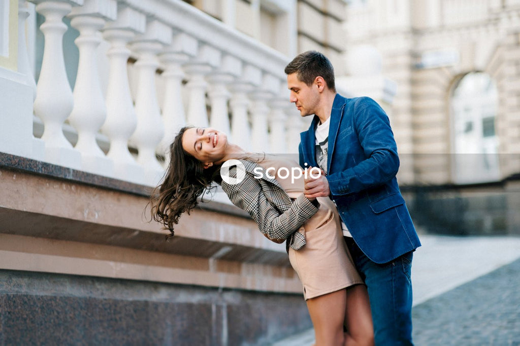 Man in blue suit jacket hugging woman in gray coat