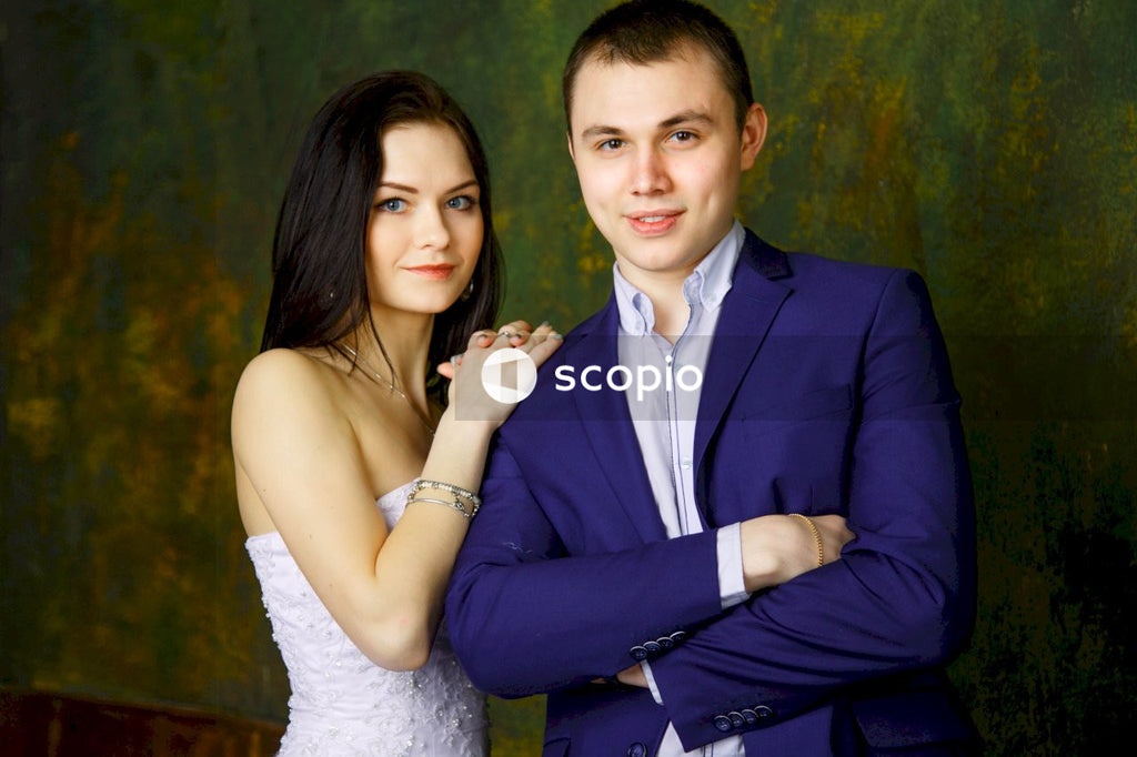 Man in blue suit jacket hugging woman in white floral lace dress