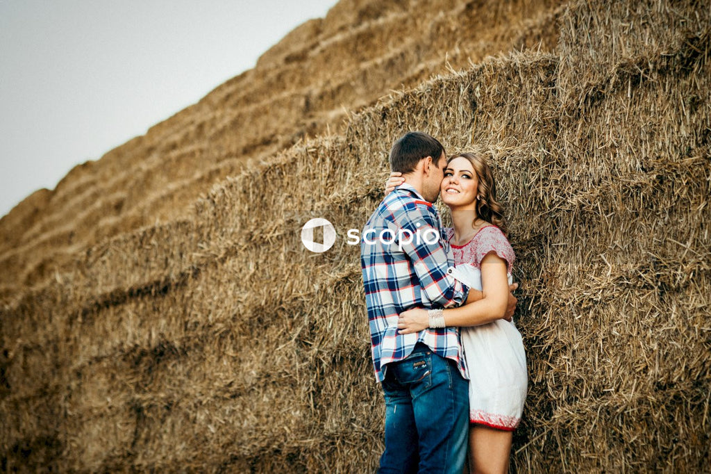 Man in blue white and red plaid dress shirt hugging woman in white shirt