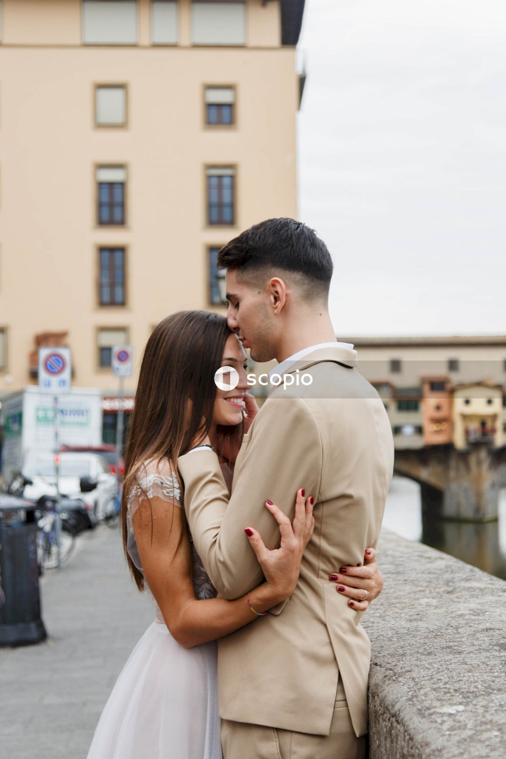 Man in brown dress shirt hugging woman in brown dress
