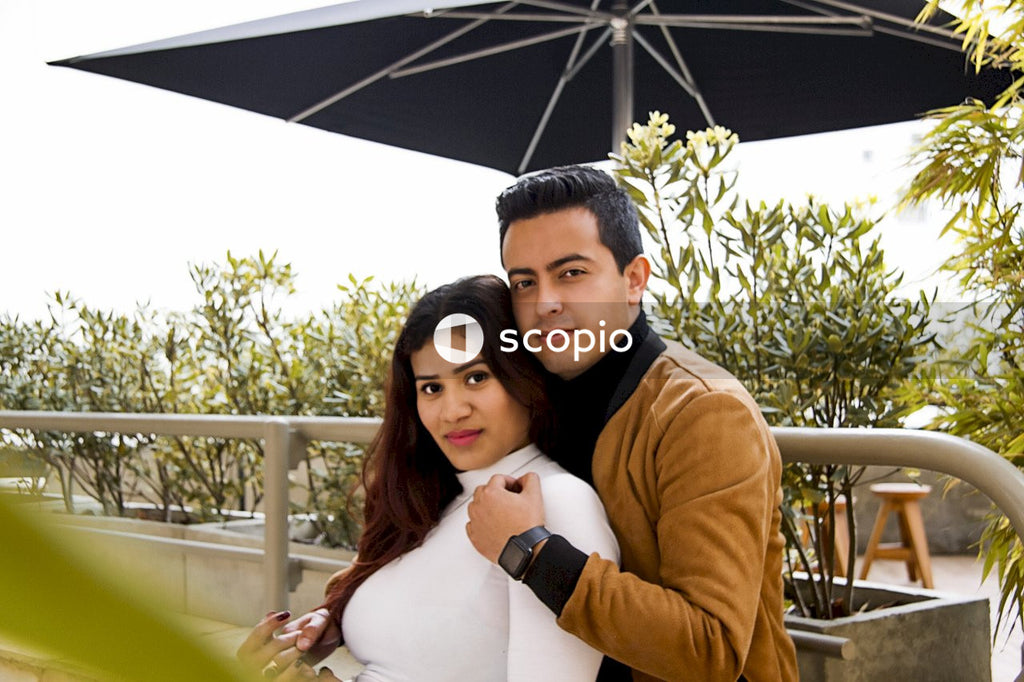 Man in brown long sleeve shirt hugging woman in white long sleeve shirt
