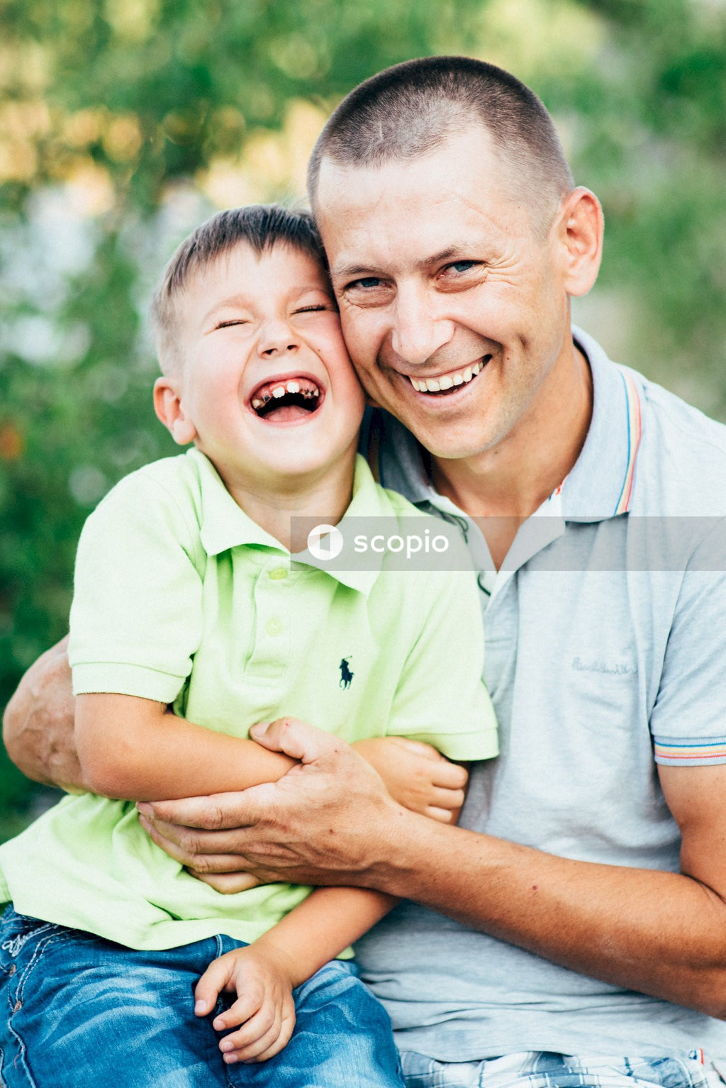 Man in gray polo shirt hugging woman in green polo shirt