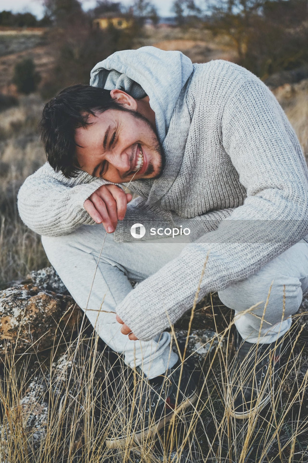 Man in gray sweater hugging woman in gray sweater
