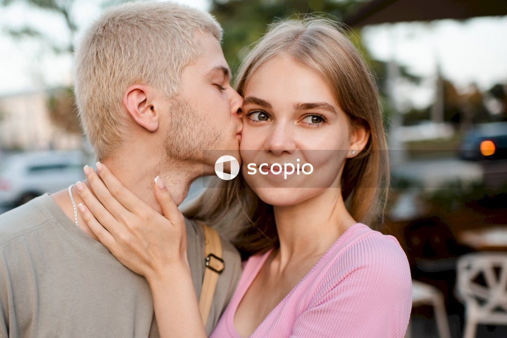 Man in pink dress shirt hugging woman in gray shirt