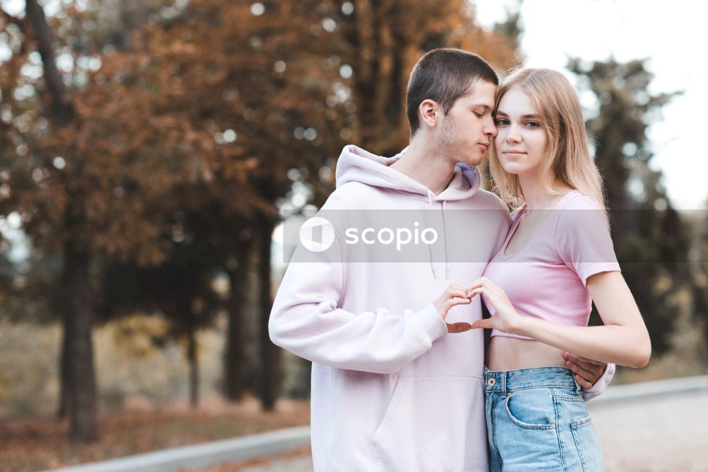 Man in pink dress shirt hugging woman in white long sleeve shirt