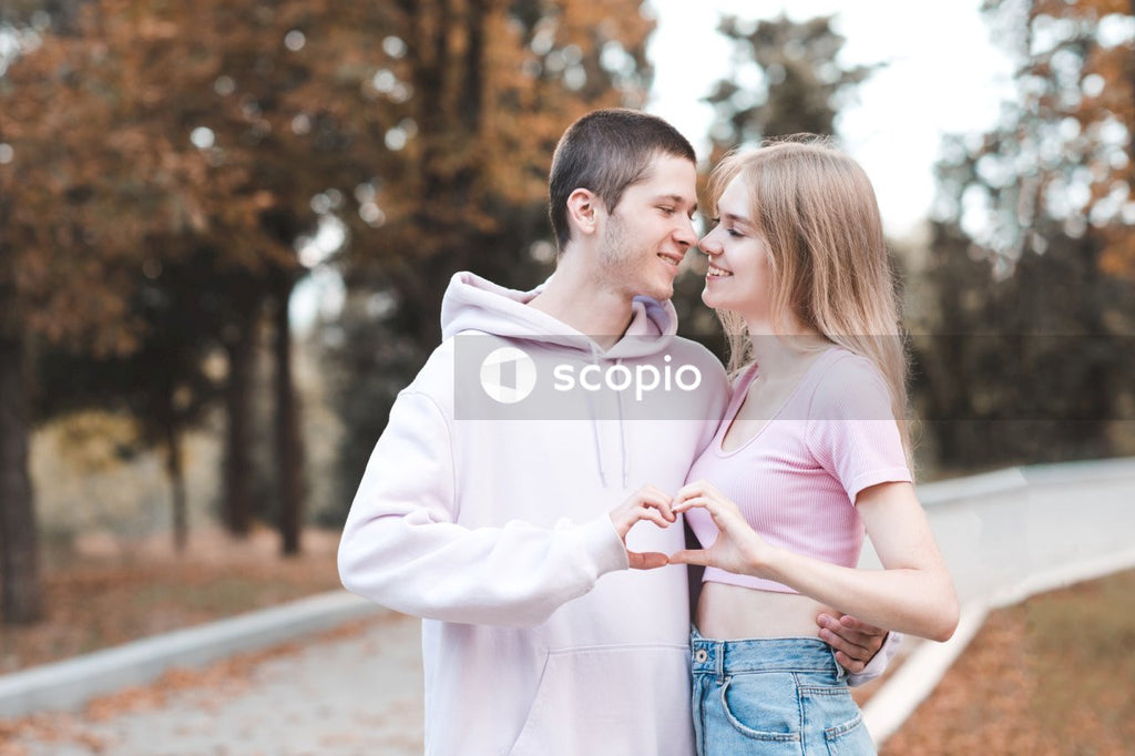 Man in pink dress shirt kissing woman in white dress