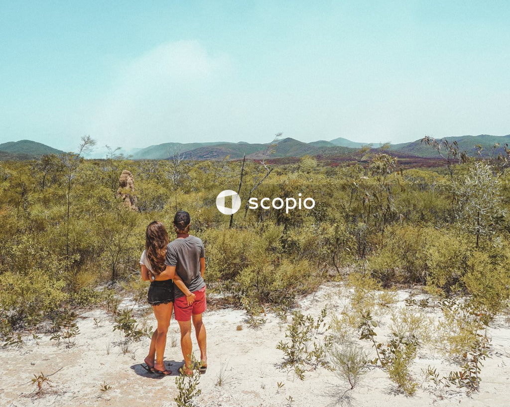 Man and woman hugging and looking at green field