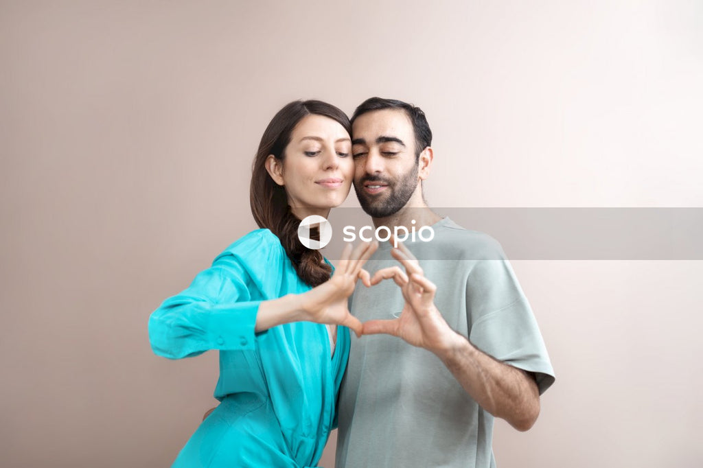 Man in teal button up shirt hugging woman in gray shirt