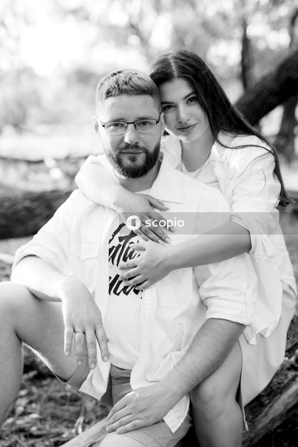 Man in white button up shirt hugging woman in white shirt