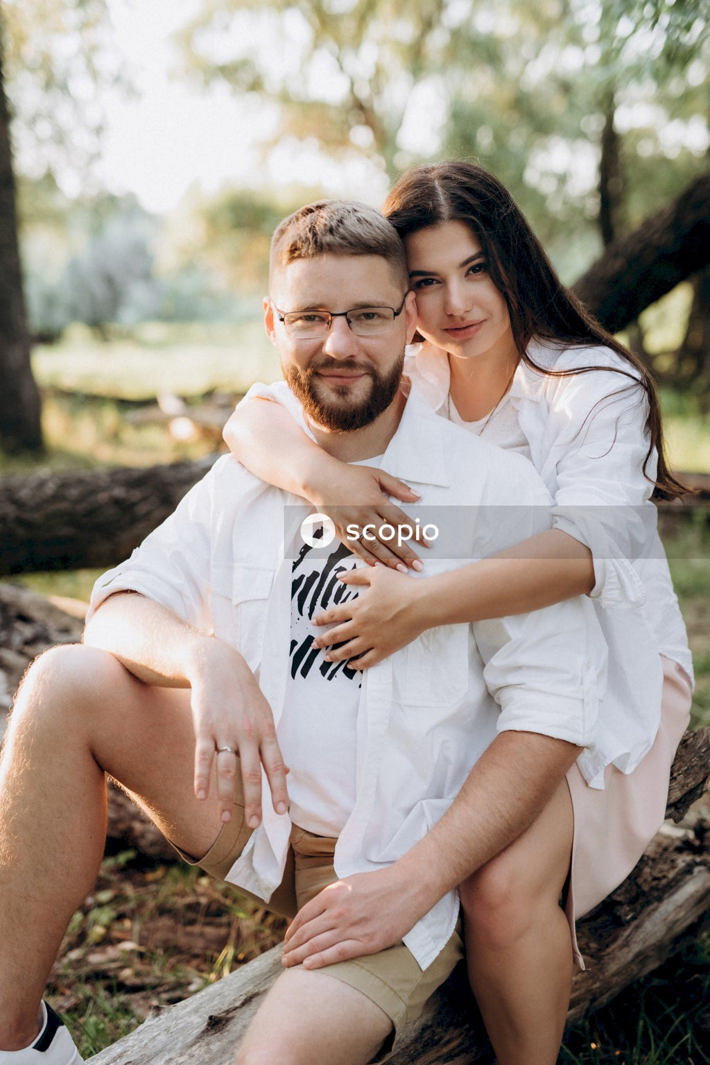 Man in white button up shirt hugging woman in white shirt