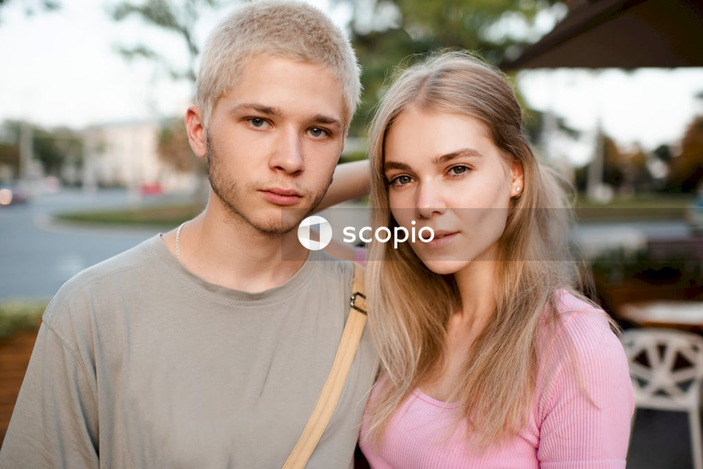 Man in white crew neck shirt beside woman in pink tank top