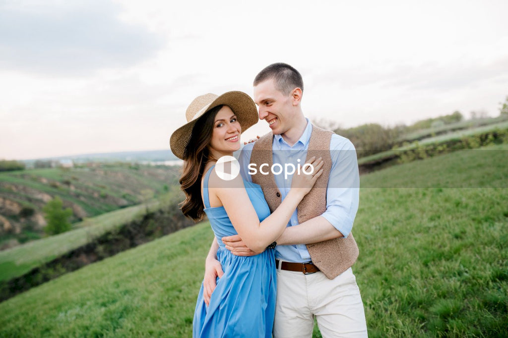 Man in white dress shirt hugging woman in blue dress