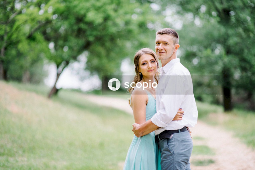 Man in white dress shirt hugging woman in blue dress