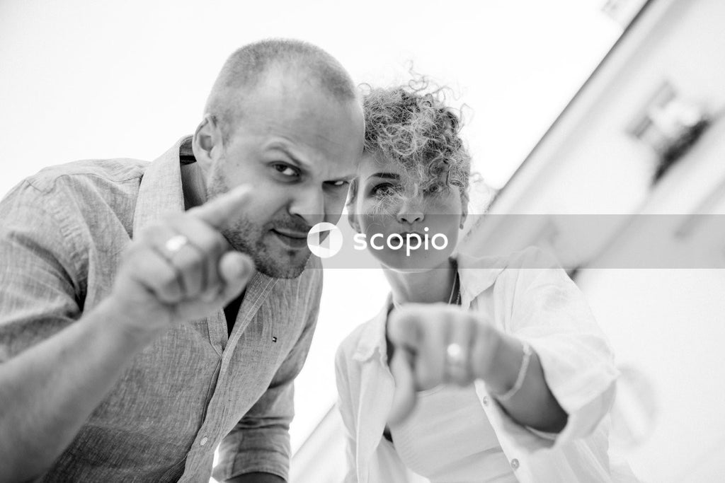Man in white dress shirt hugging woman in gray long sleeve shirt