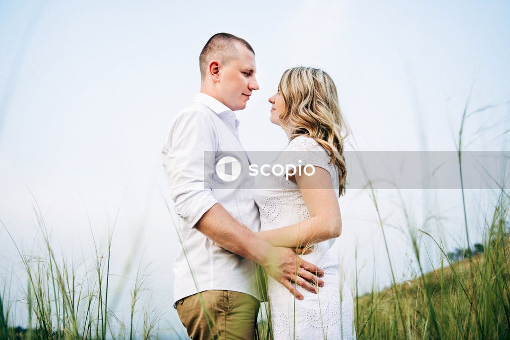 Man in white dress shirt hugging woman in green dress