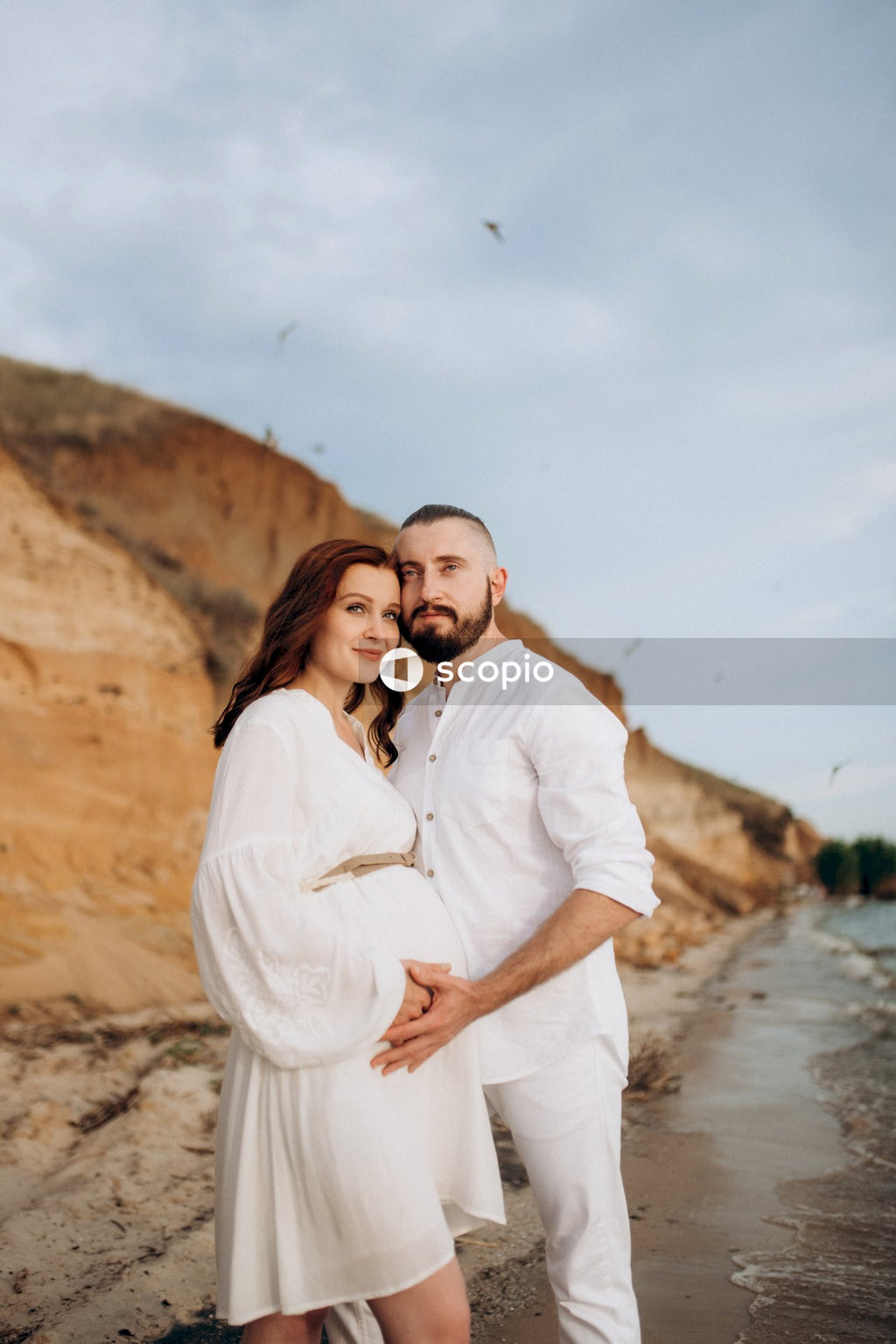 Man in white dress shirt hugging woman in white dress