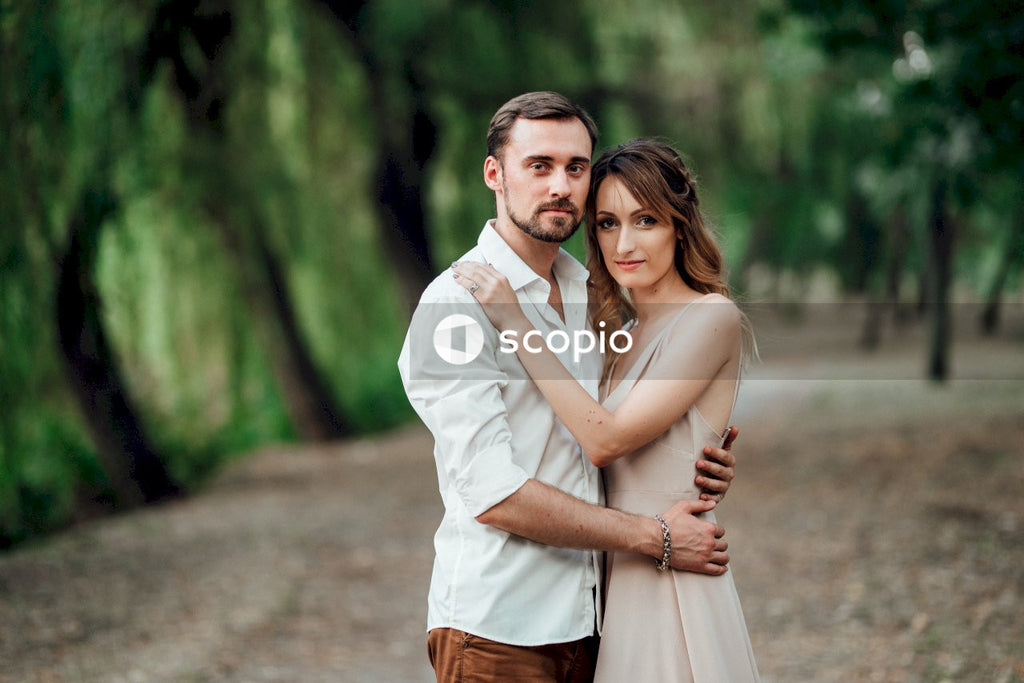 Man in white dress shirt hugging woman in white dress