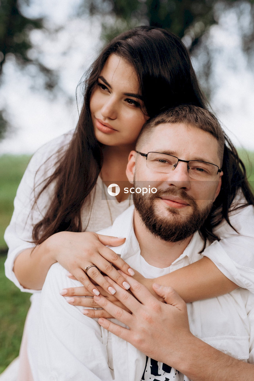 Man in white dress shirt hugging woman in white dress