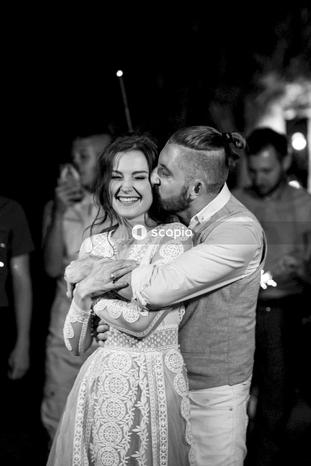 Man in white dress shirt hugging woman in white dress