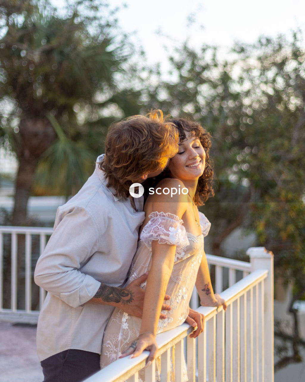 Man in white dress shirt hugging woman in white dress