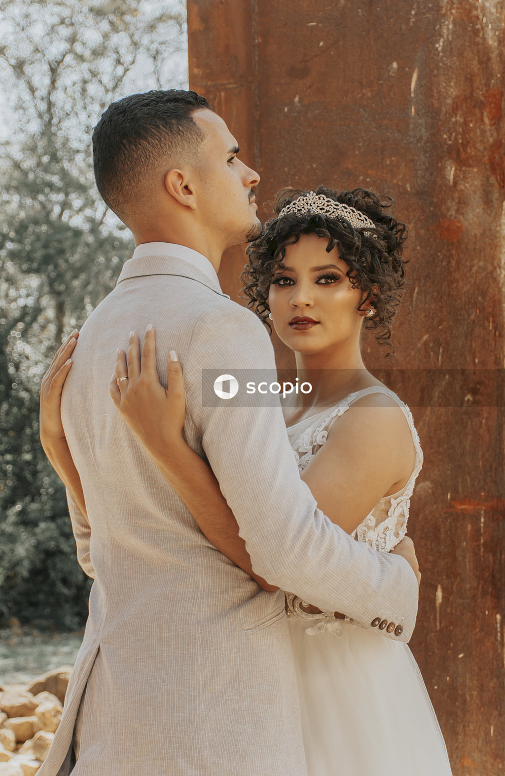 Man in white dress shirt hugging woman in white dress