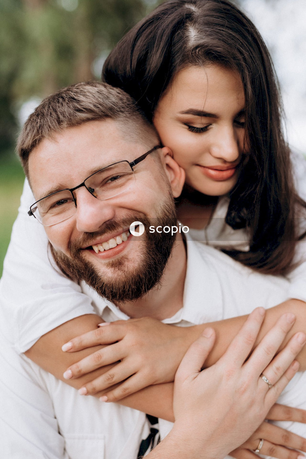 Man in white dress shirt hugging woman in white dress