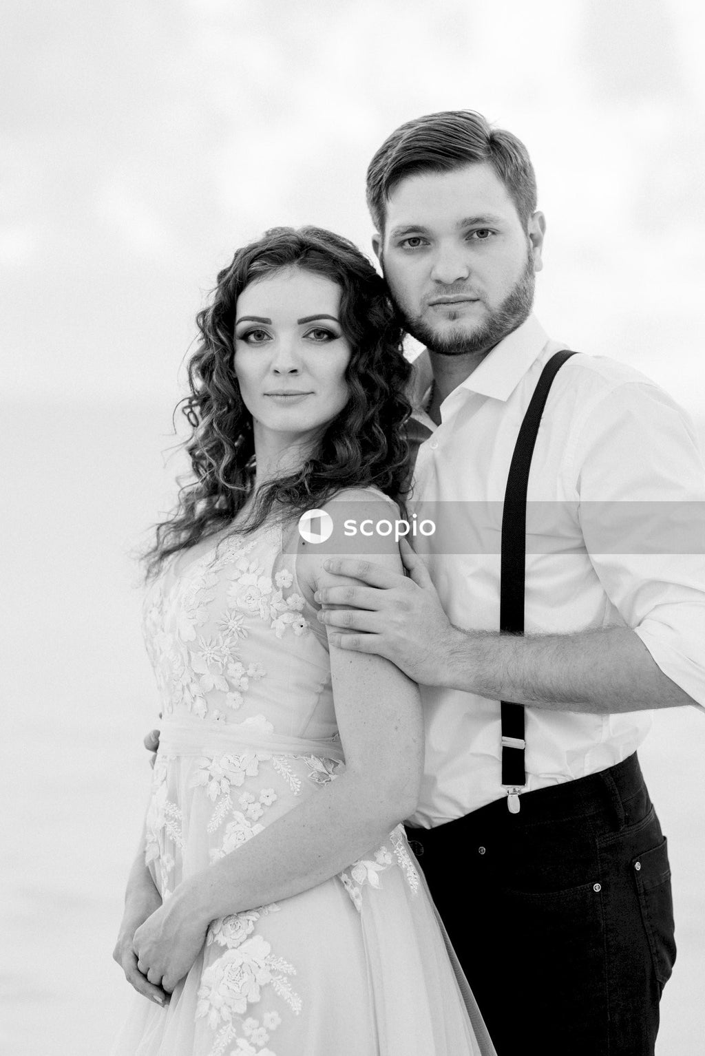 Man in white dress shirt hugging woman in white dress