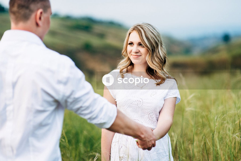 Man in white dress shirt hugging woman in white dress