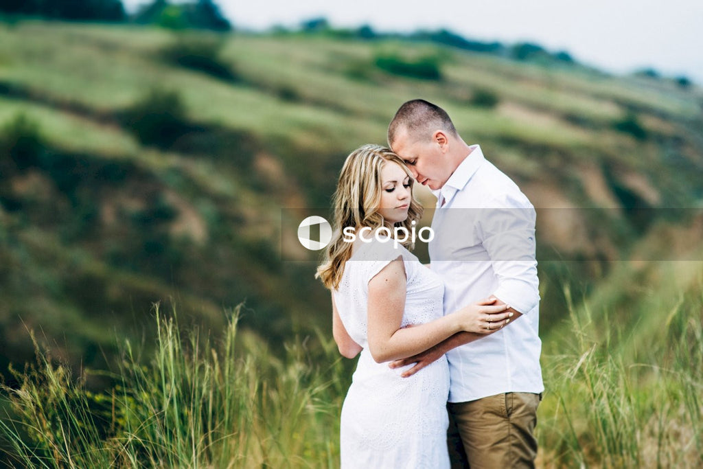 Man in white dress shirt hugging woman in white dress