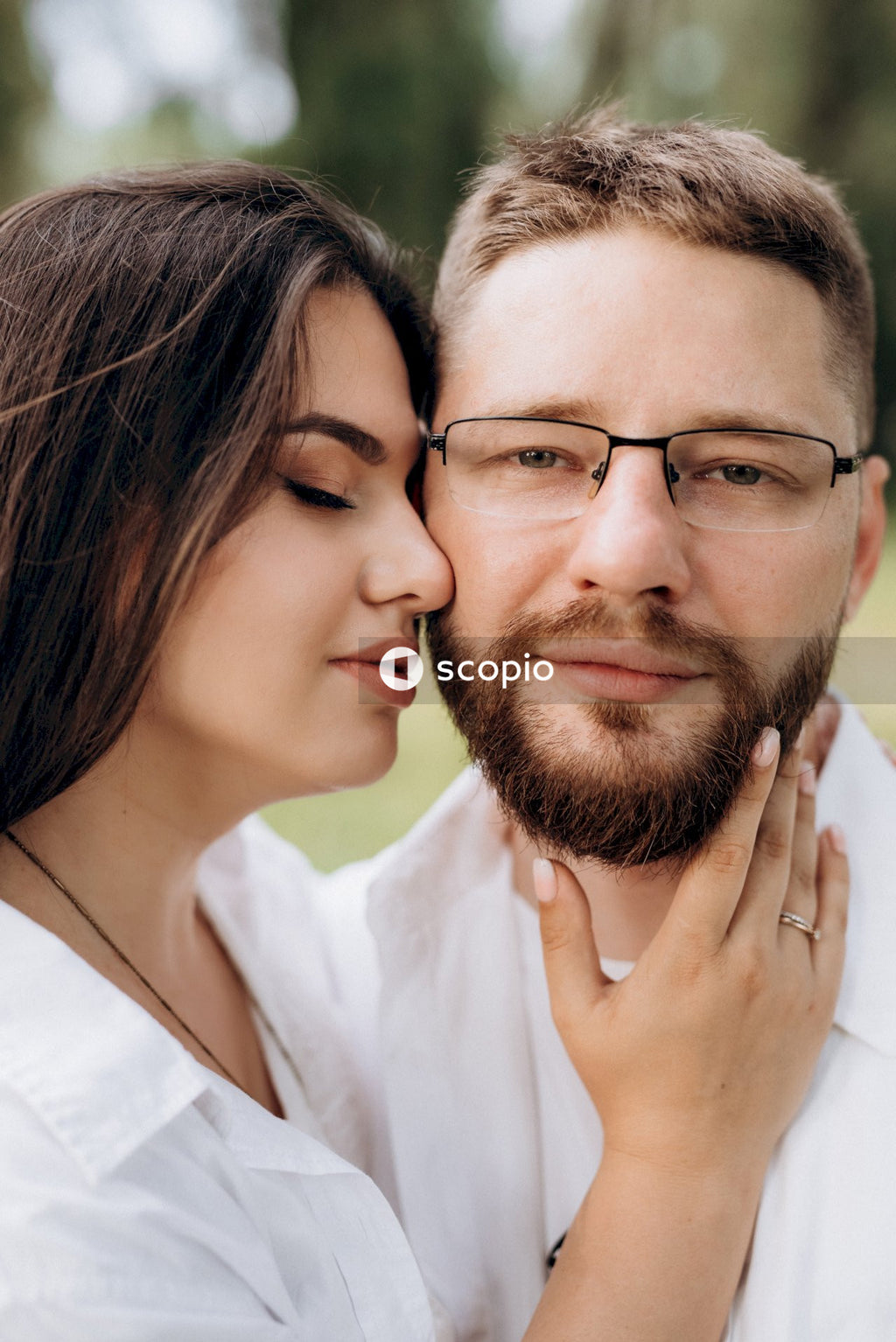 Man in white dress shirt hugging woman in white dress shirt