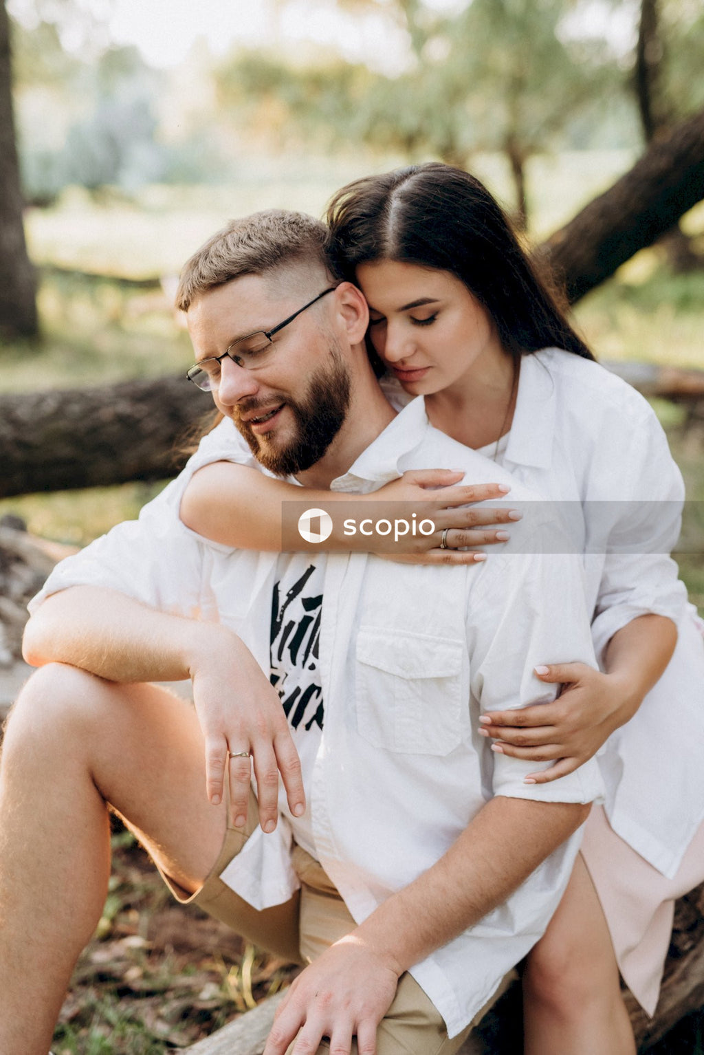 Man in white dress shirt hugging woman in white long sleeve shirt