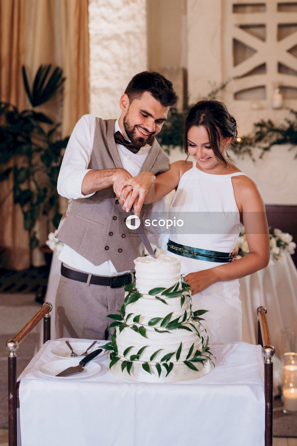 Man in white dress shirt hugging woman in white sleeveless dress