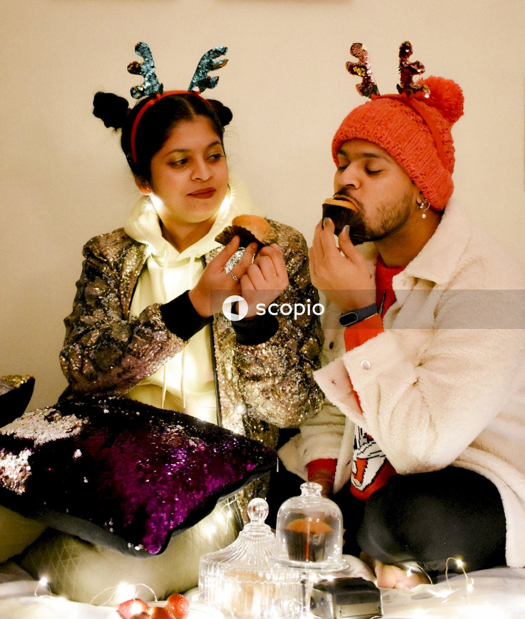 Man in white dress shirt sitting beside woman in red and white hijab