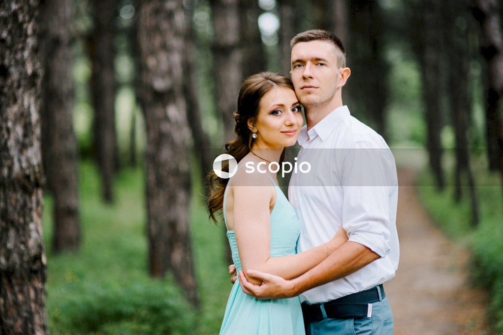 Man in white dress shirt standing beside woman in blue dress