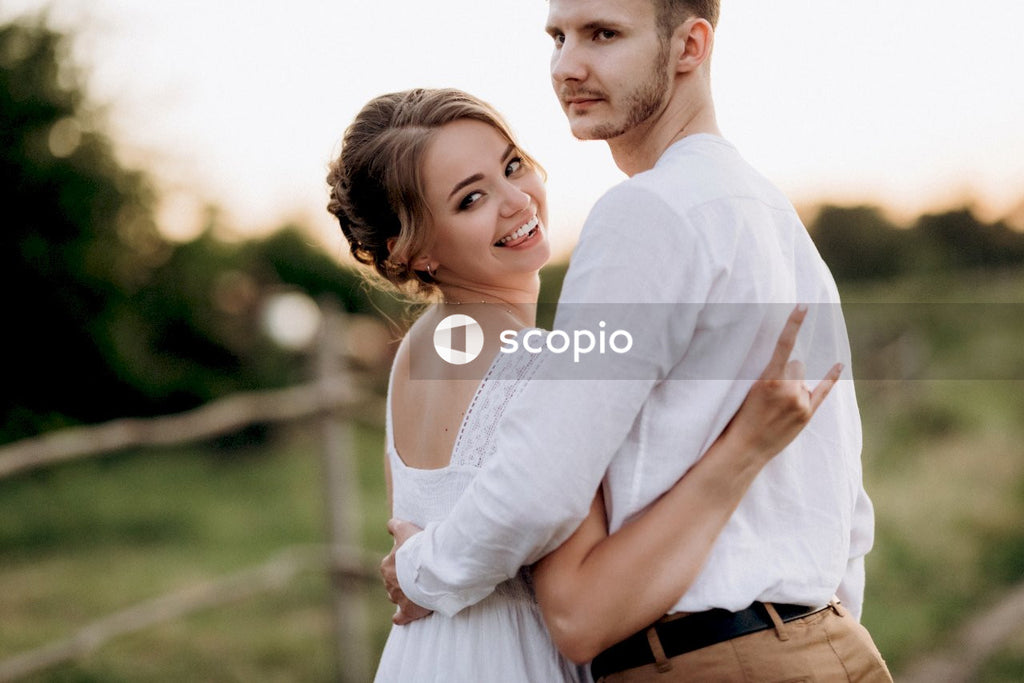 Man in white long sleeve shirt hugging woman in white long sleeve shirt