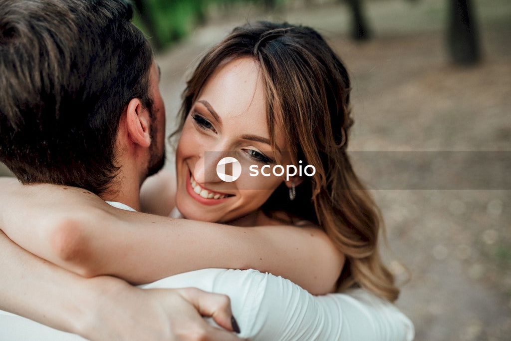 Man in white long sleeve shirt hugging woman in white long sleeve shirt