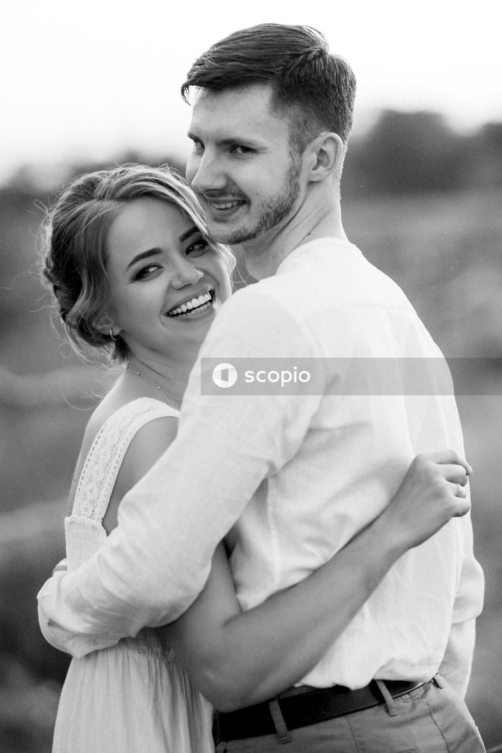 Man in white long sleeve shirt hugging woman in white long sleeve shirt