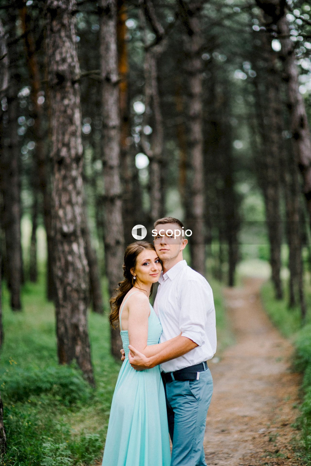 Man in white polo shirt hugging woman in white dress